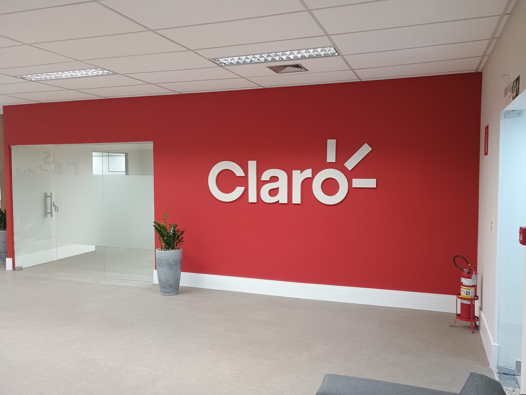 RECEPÇÃO — Parede de identidade visual com a marca Claro e nova iluminação
